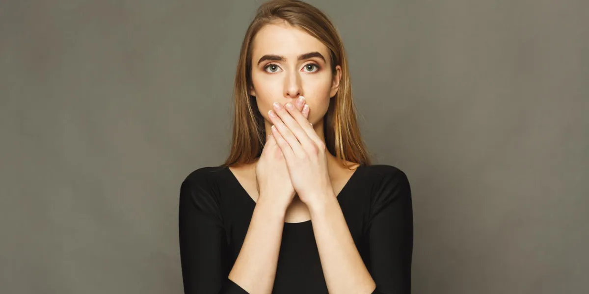 confused woman puts her hands on lips portrait of young girl closing her mouth, tell nothing, secret concept