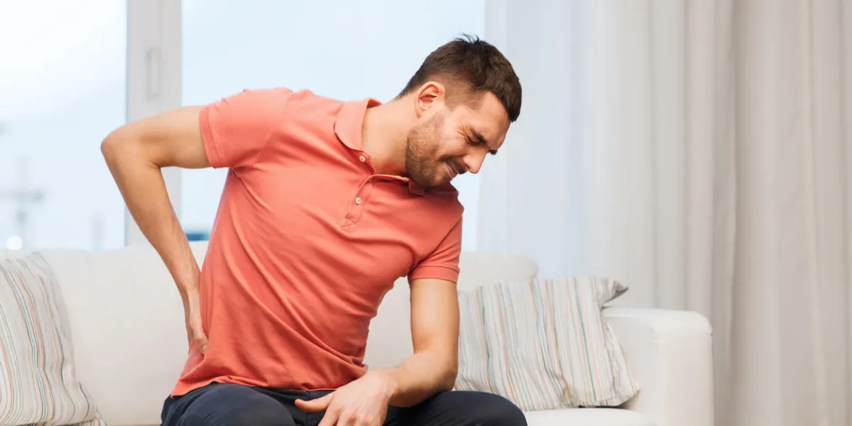 gens, soins de santé et concept de problème - malheureux homme souffrant de douleurs dans le dos ou les rênes à la maison