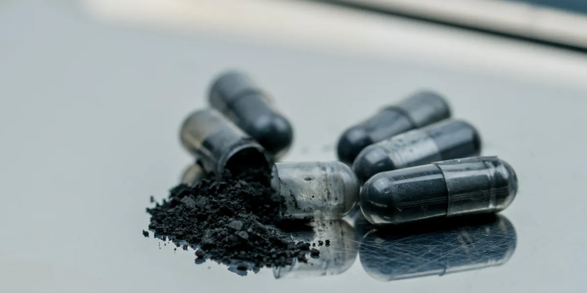 selective focus on powders of activated charcoal on stainless steel drug tray and blur capsule background selective focus on powders of activated charcoal on stainless steel drug tray and blur capsule background