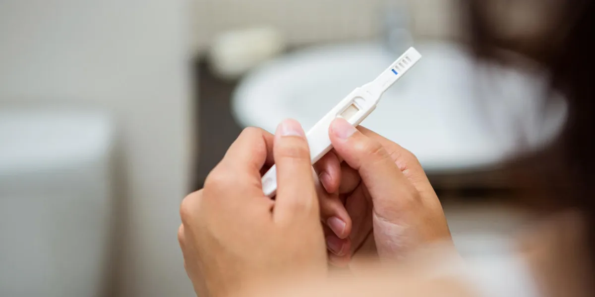 close-up of woman holding a pregnancy test in the bathroom close-up of woman holding a pregnancy test in the bathroom