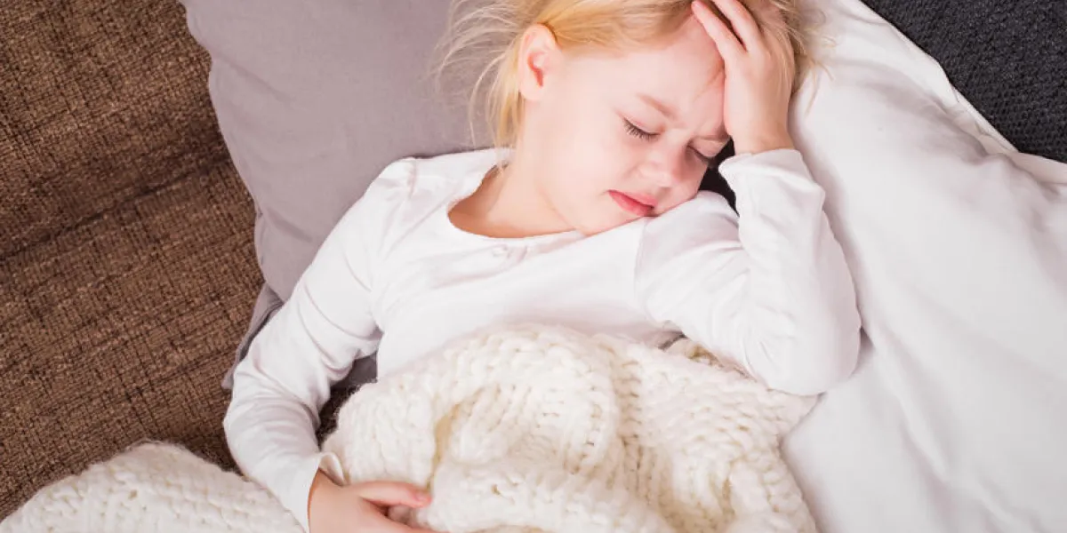 petit enfant malade et tenant sa main contre son front