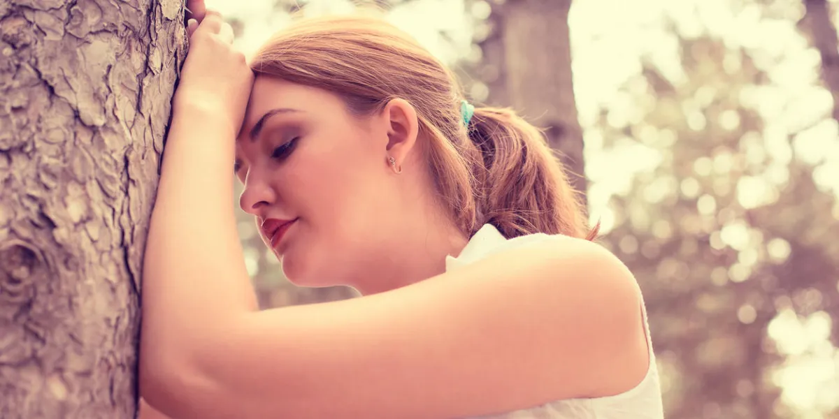 portrait stressed sad young woman standing outdoors on summer day in park