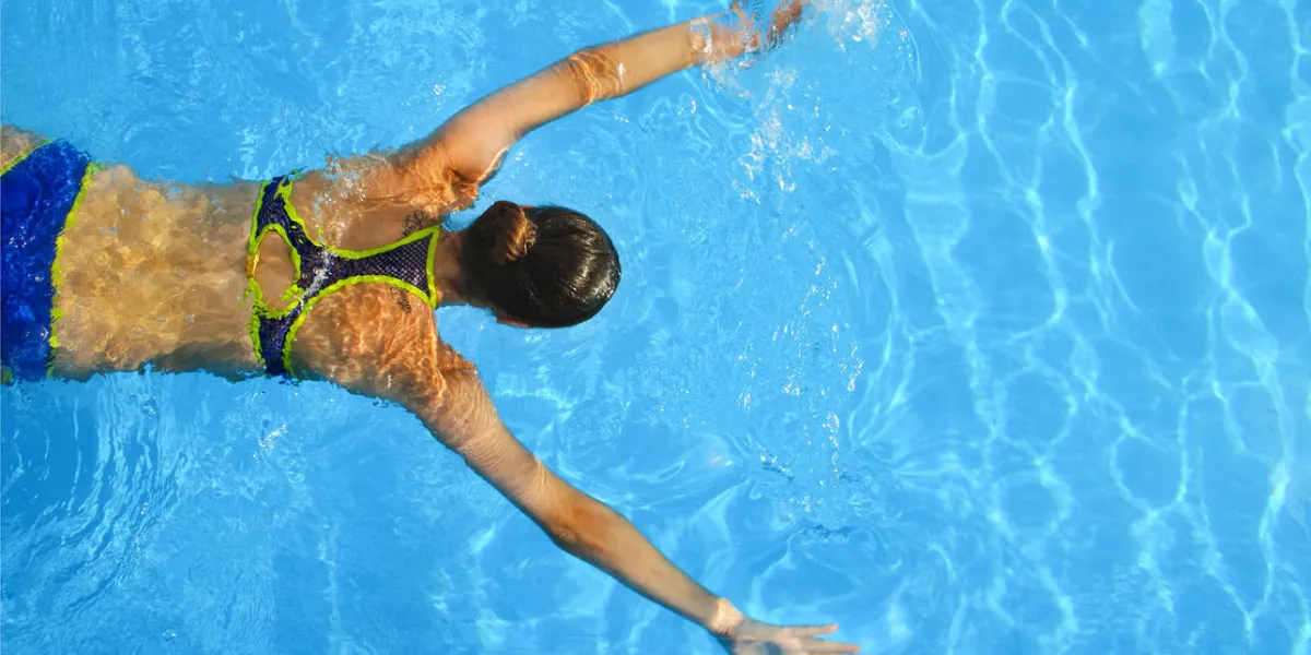 jeune femme nageant dans une eau bleue de piscine piscine sous-marine