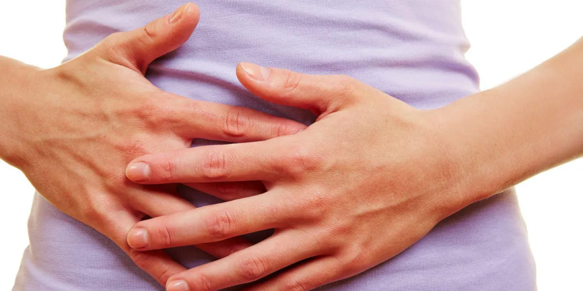 femme avec des douleurs abdominales et des crampes d'estomac tient ses mains à son estomac femme avec des douleurs abdominales et des crampes d'estomac tient ses mains à son estomac