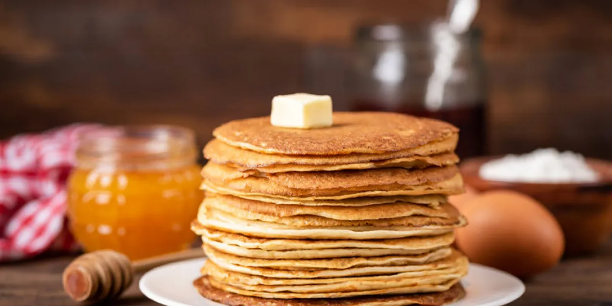 blini or crepe or thin pancakes stack on wooden table topped with butter shrove tuesday, maslenitsa holiday concept rustic style breakfast blini or crepe or thin pancakes stack on wooden table topped with butter shrove tuesday, maslenitsa holiday concept rustic style breakfast