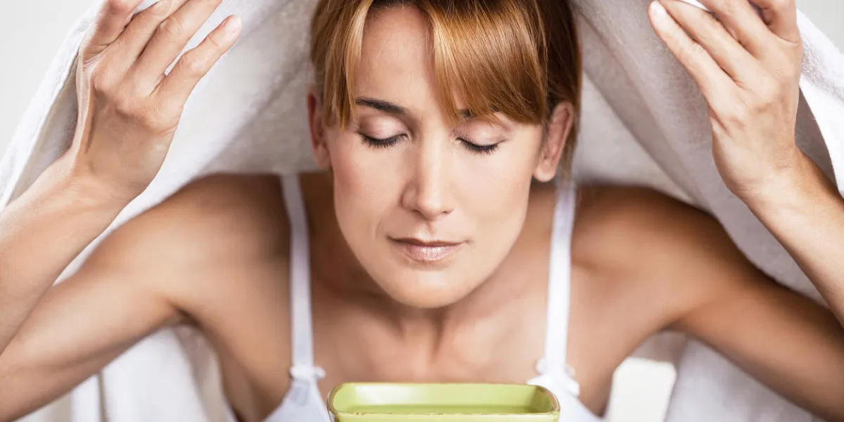 portrait of a woman inhaling over a bowl