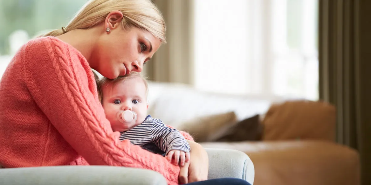 mother suffering from post natal depression hugging child