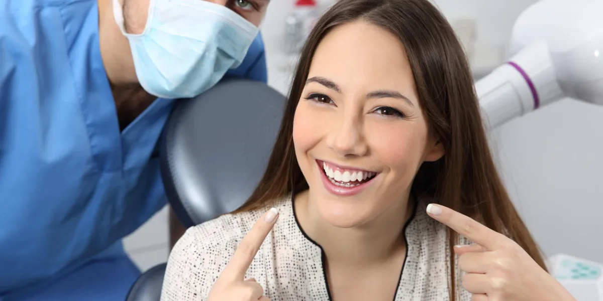 satisfied dentist patient showing her perfect smile in a consultation satisfied dentist patient showing her perfect smile in a consultation