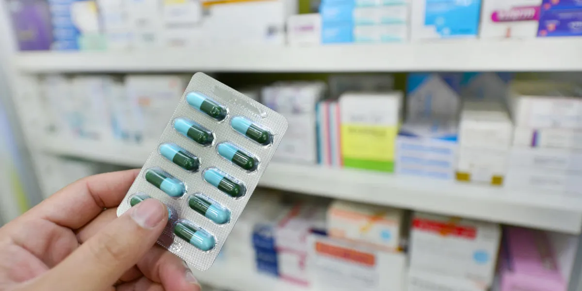 pharmacist holding medicine capsule pack at the pharmacy drugstore