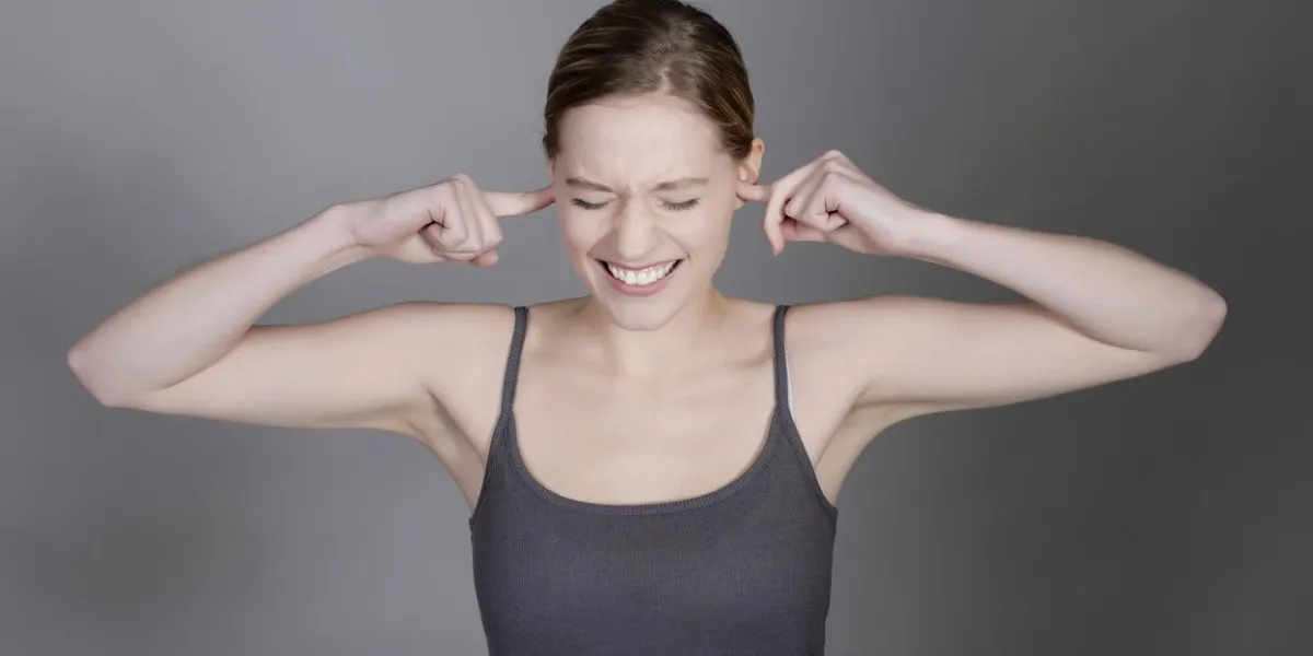 pretty young woman holding her ears with fingers