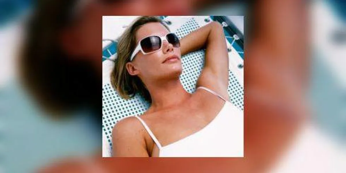 portrait d'une jeune femme se faire bronzer sur une chaise de jardin