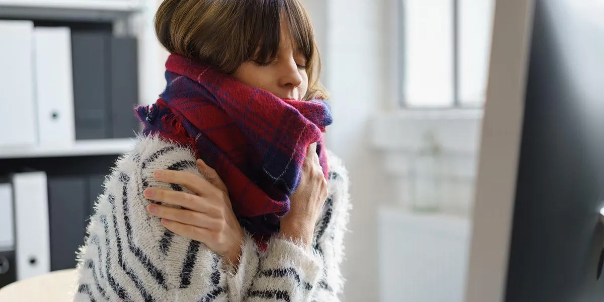 femme avec écharpe est assis à l'ordinateur et se sent malade femme avec écharpe est assis à l'ordinateur et se sent malade