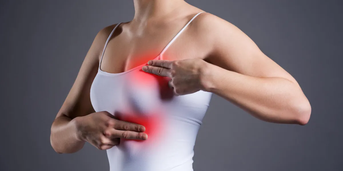 breast test, woman examining her breasts for cancer, heart attack, pain in human body on gray background breast test, woman examining her breasts for cancer, heart attack, pain in human body on gray background
