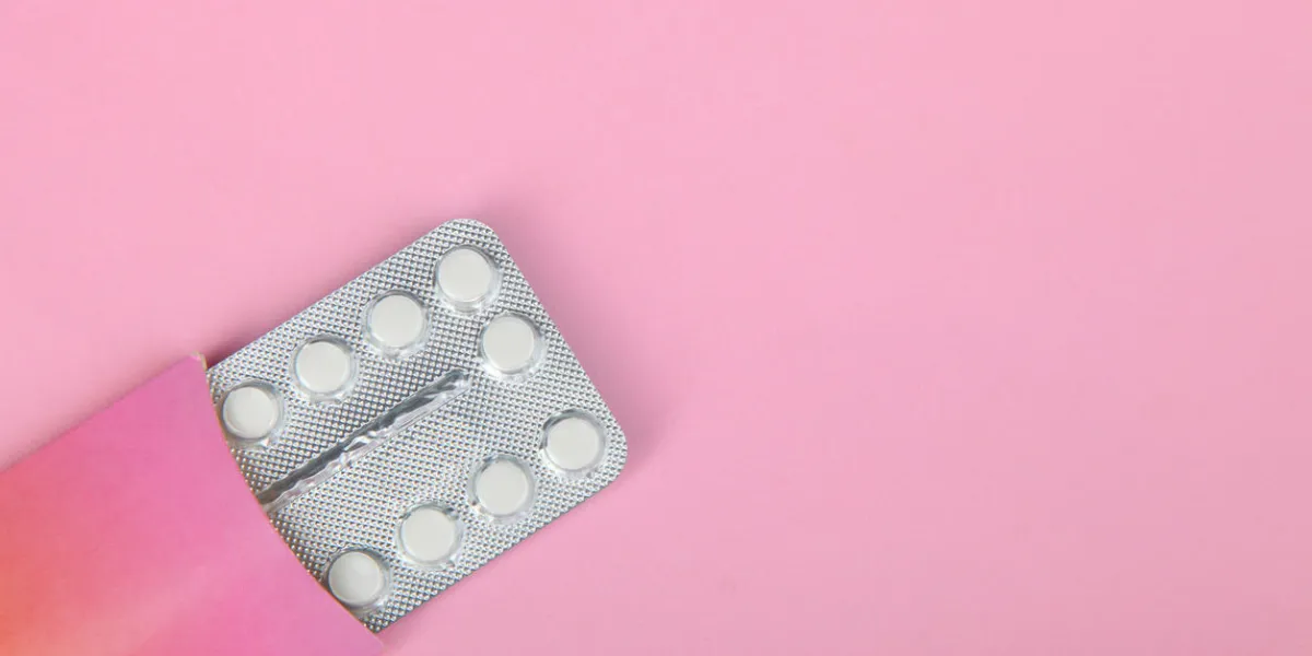 contraceptive pills in the package on a pink background