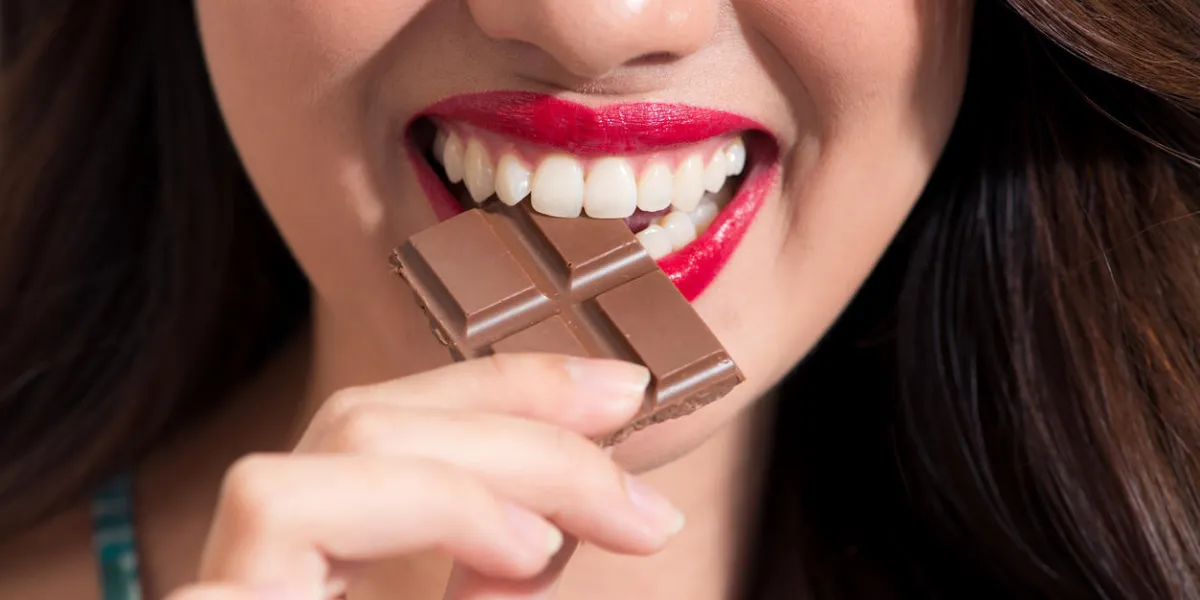 closeup of a woman with red lipstick eats chocolate closeup of a woman with red lipstick eats chocolate