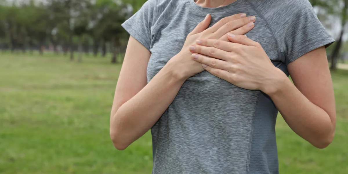 sport woman having a pain in the heart area heart health, high blood pressure prevention concept