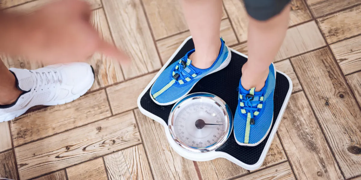 the father weighs his son on the scales he wants to know his weight they do gymnastics together the father weighs his son on the scales he wants to know his weight they do gymnastics together