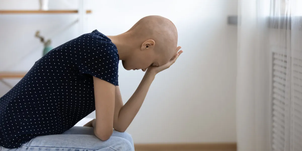 stressed frustrated depressed young bald woman sitting on bed, feeling unwell alone at home or oncology treatment center, worrying about future operation, thinking of disease fighting alone indoors stressed frustrated depressed young bald woman sitting on bed, feeling unwell alone at home or oncology treatment center, worrying about future operation, thinking of disease fighting alone indoors