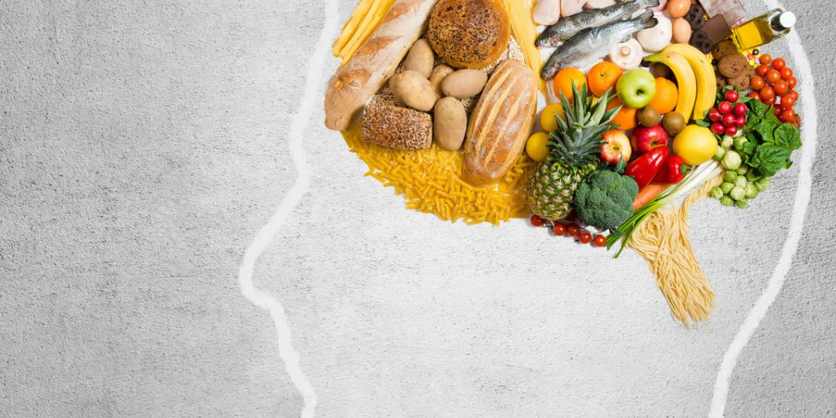 human head shape with variety of different food ingredients on gray background