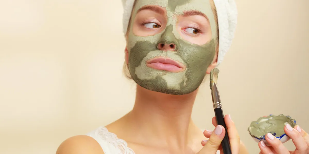 skin care woman applying with brush clay mud mask to her face girl taking care of oily complexion beauty treatment