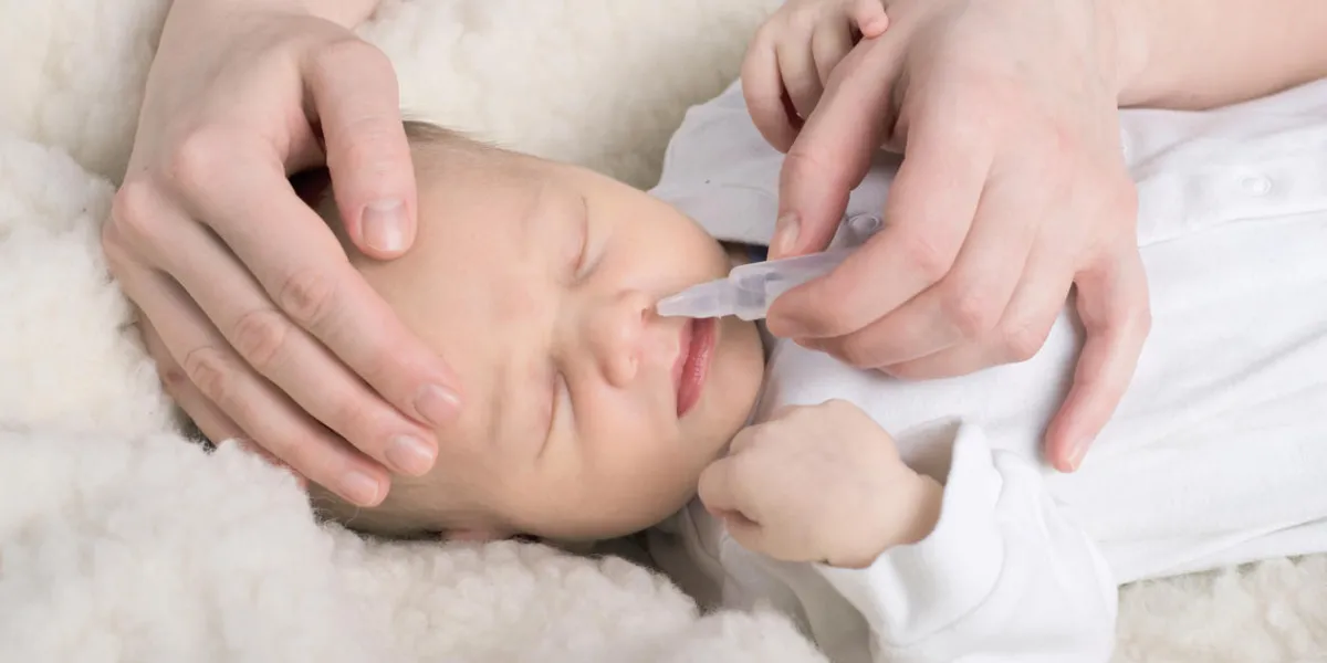 ill newborn baby gets nose drops