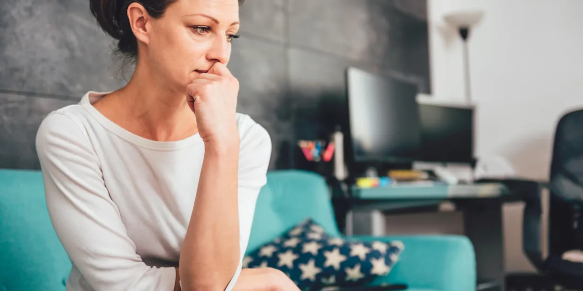 femme triste assis sur un canapé dans le salon femme triste assis sur un canapé dans le salon
