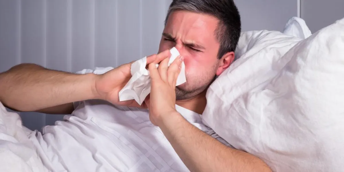 homme infecté par le rhume et la grippe se mouchant le nez dans du papier de soie homme infecté par le rhume et la grippe se mouchant le nez dans du papier de soie