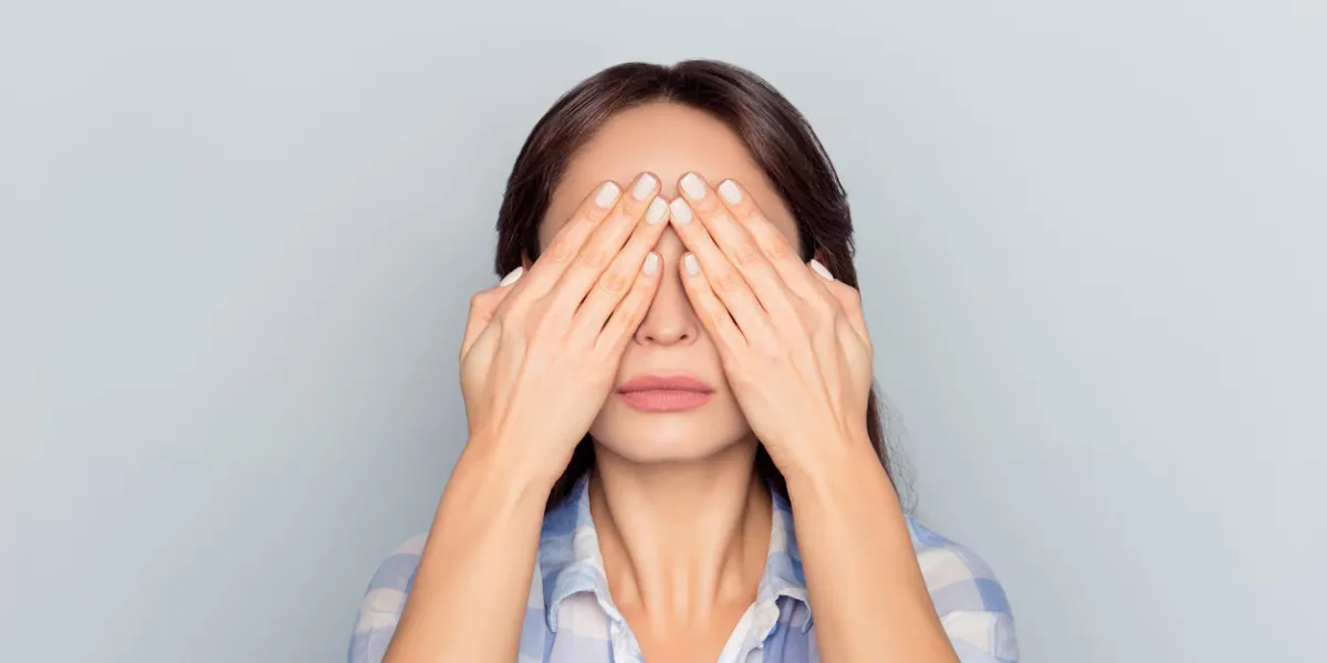 close up portrait of tired woman after long working day on computer having eye problem, pressure, covering face, eyes with hands, afraid to look, standing over grey background close up portrait of tired woman after long working day on computer having eye problem, pressure, covering face, eyes with hands, afraid to look, standing over grey background
