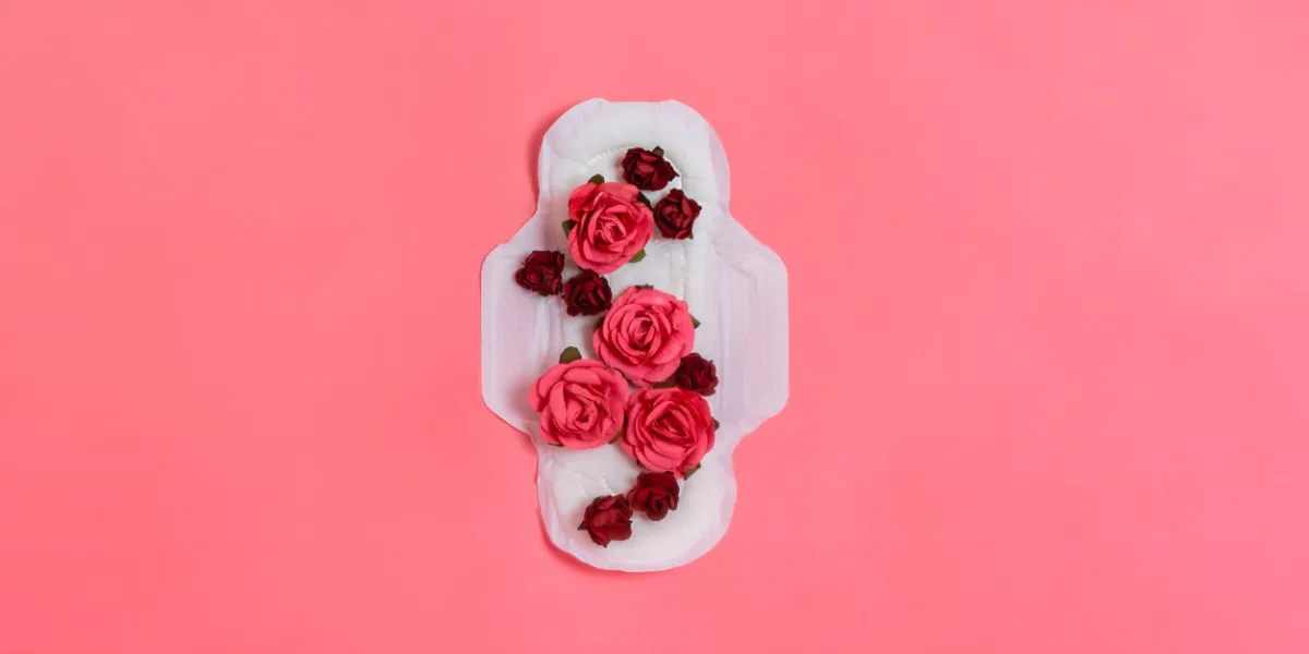 white sanitary pad with red and pink flowers on it, woman health or body positive concept pink background flatlay copyspace white sanitary pad with red and pink flowers on it, woman health or body positive concept pink background flatlay copyspace