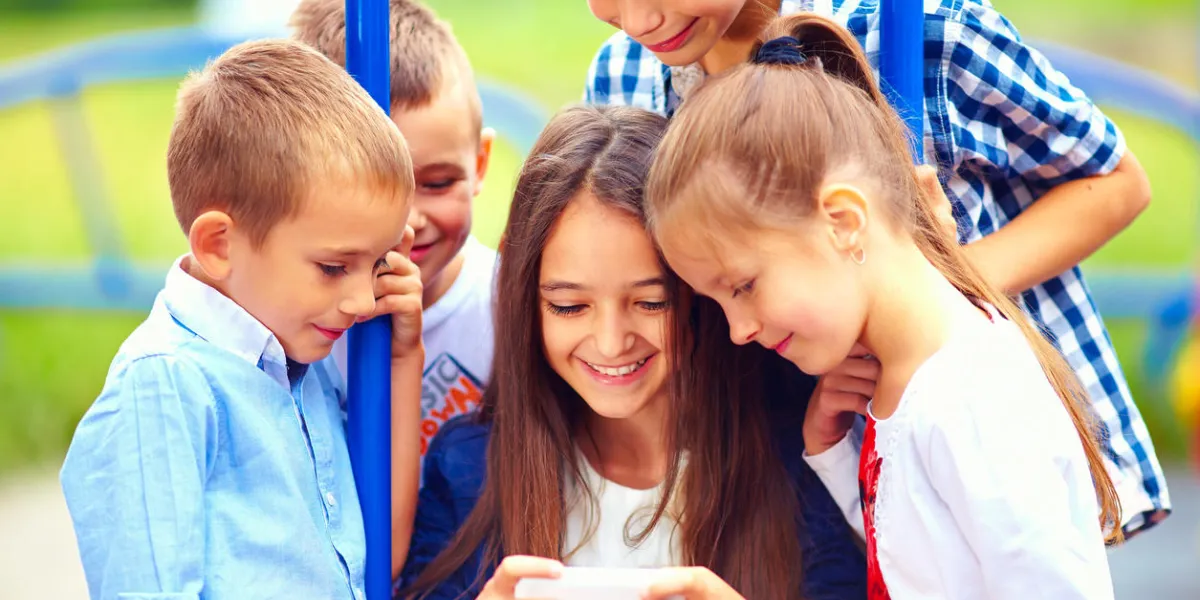 group of happy kids playing online games together, outdoors group of happy kids playing online games together, outdoors