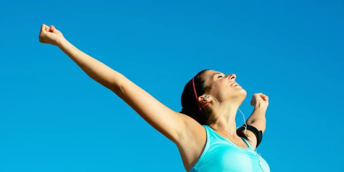 femme heureuse de remise en forme heureuse levant les bras vers le ciel après le succès sportif fille sportive de plein air bénéficiant de la liberté