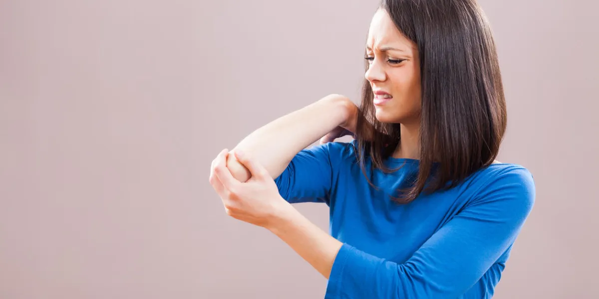 portrait of young woman who is having pain in her elbow portrait of young woman who is having pain in her elbow