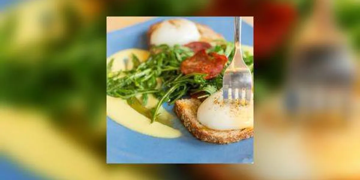 oeuf bénédictine sur une plaque bleue avec une fourchette poke sur le jaune oeuf bénédictine sur une plaque bleue avec une fourchette poke sur le jaune