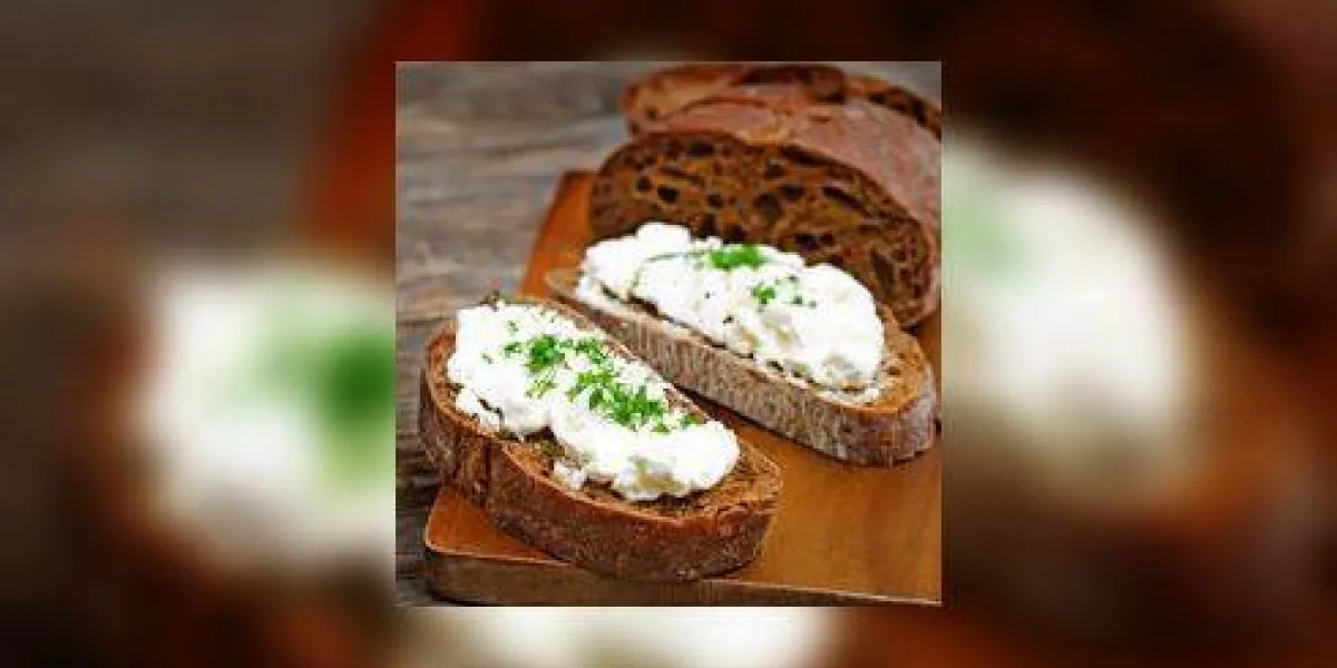 pain de seigle avec du fromage à la crème et de l'aneth sur un fond de bois foncé coloration mise au point sélective