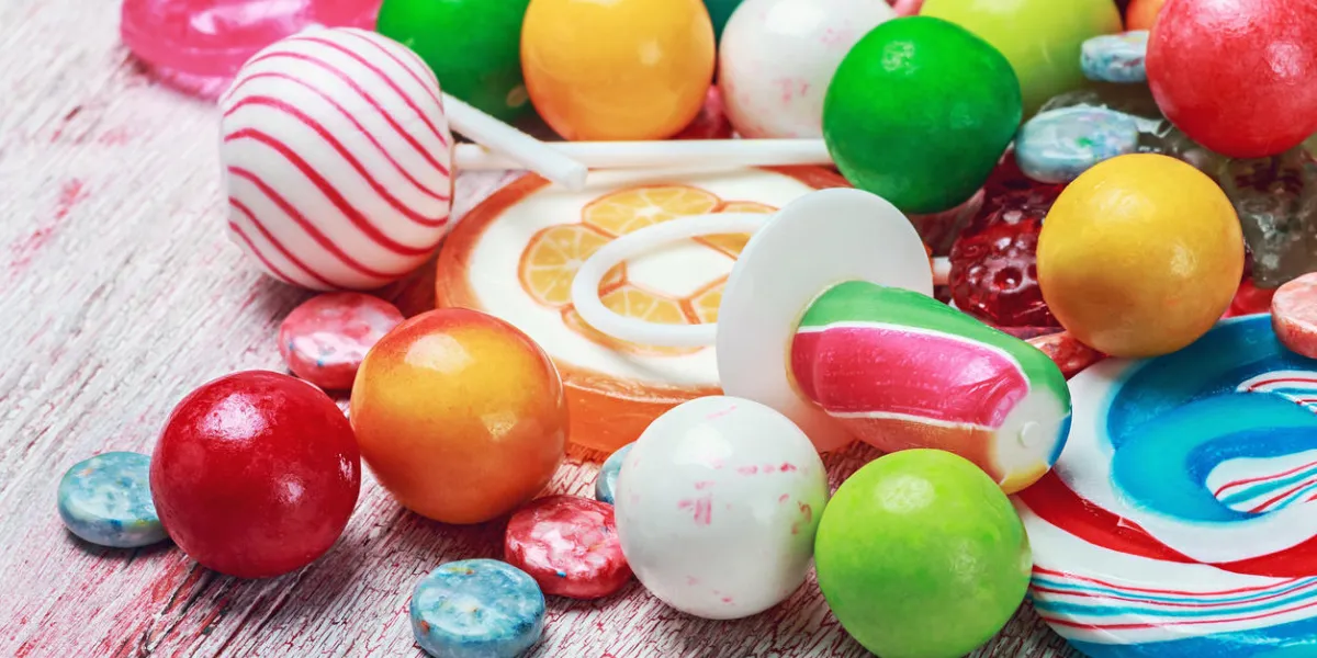 sucettes multicolores et bonbons sur une table en bois