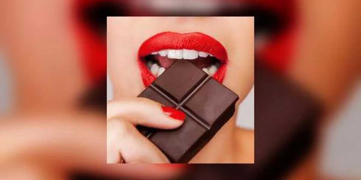 se livrer à une douce affaire avec du chocolat gros plan d'une belle femme tenant le doigt sur ses lèvres rouges en se tenant debout sur fond gris se livrer à une douce affaire avec du chocolat gros plan d'une belle femme tenant le doigt sur ses lèvres rouges en se tenant debout sur fond gris