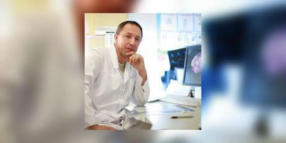 un portrait de docteur assis avec chat scan sur le moniteur et des films radiographiques sur la table
