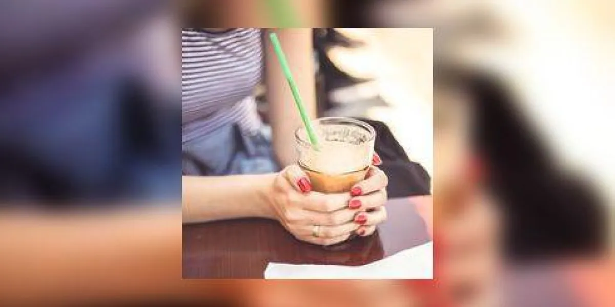 belle fille tenant un smoothie à l'extérieur dans un cadre de restaurant