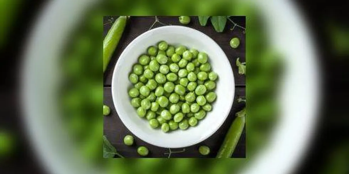 pois verts dans un bol sur la vue de dessus de fond de table en bois