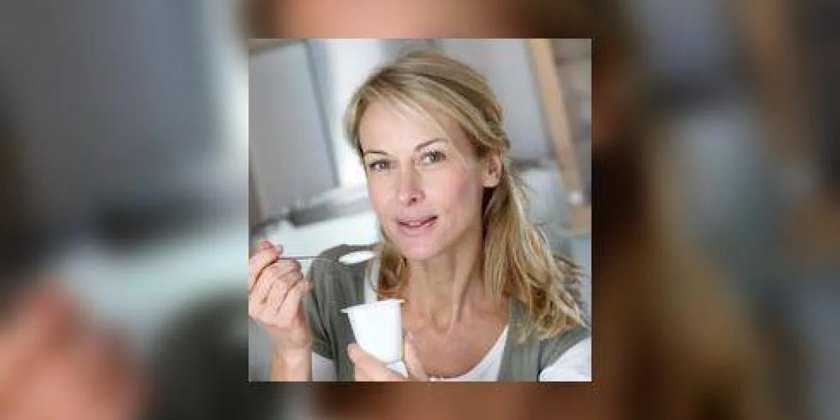 gros plan de blonde femme mature avec du yaourt dans les mains