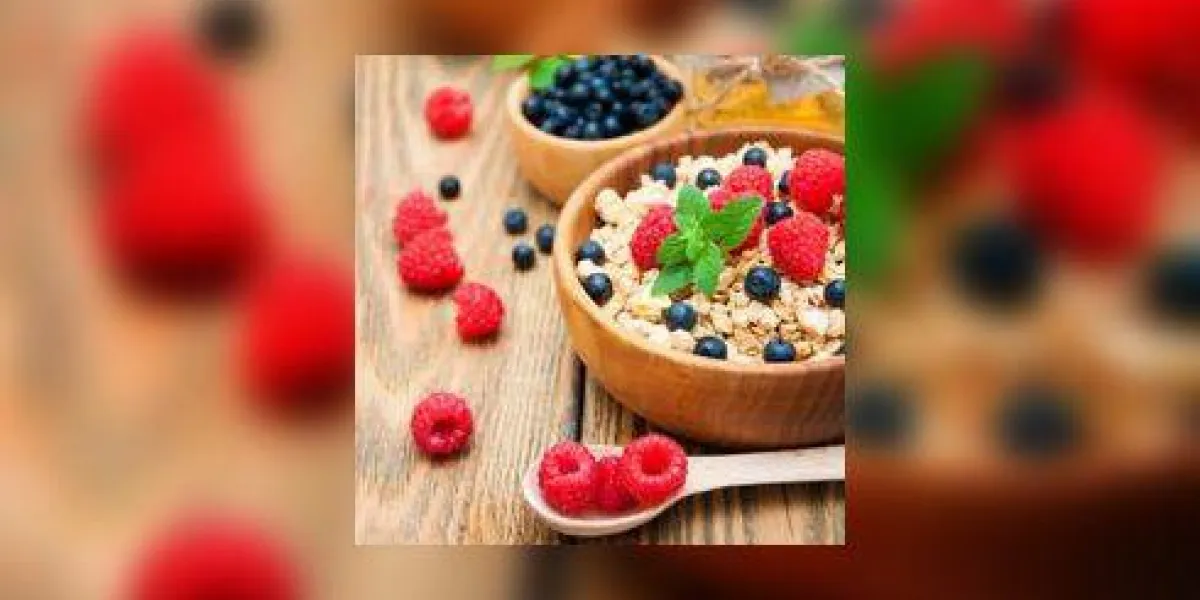 petit déjeuner avec muesli et framboises, myrtilles, miel sur la table en bois petit déjeuner avec muesli et framboises, myrtilles, miel sur la table en bois