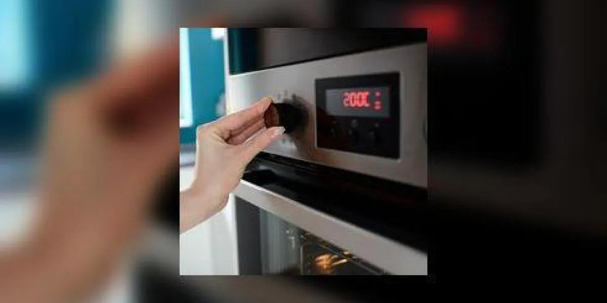 gros plan du réglage de la température de la main de la femme sur le four l'affichage montre la température réglée à 200 degrés celsius