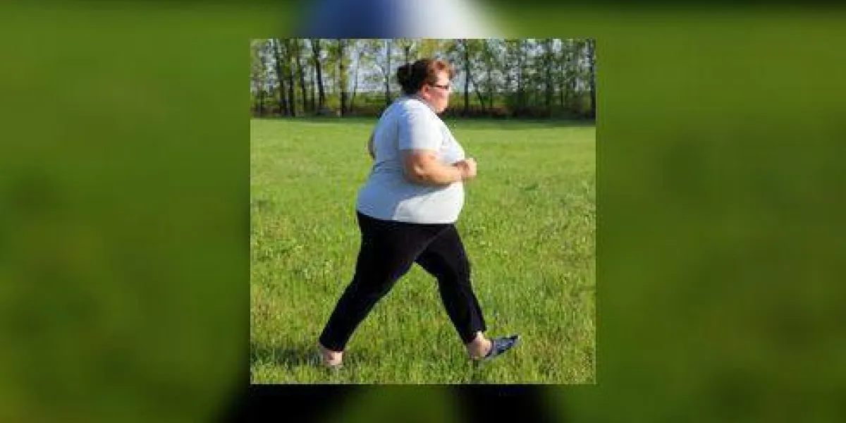 sport - femme en surpoids qui court sur le pré vert sport - femme en surpoids qui court sur le pré vert