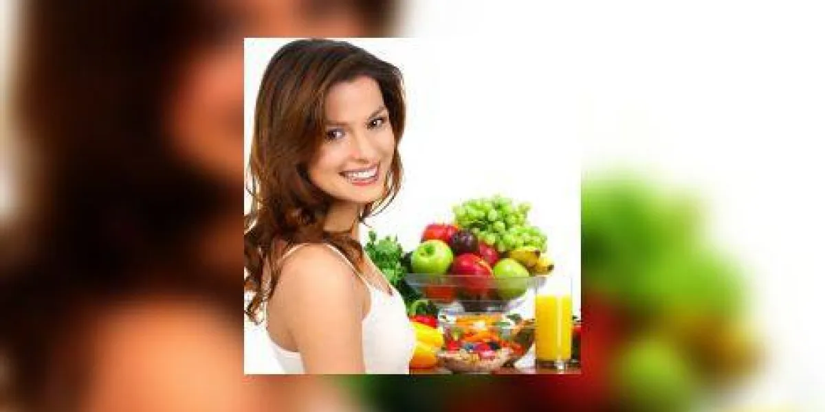jeune femme souriante avec des fruits et légumes sur fond blanc