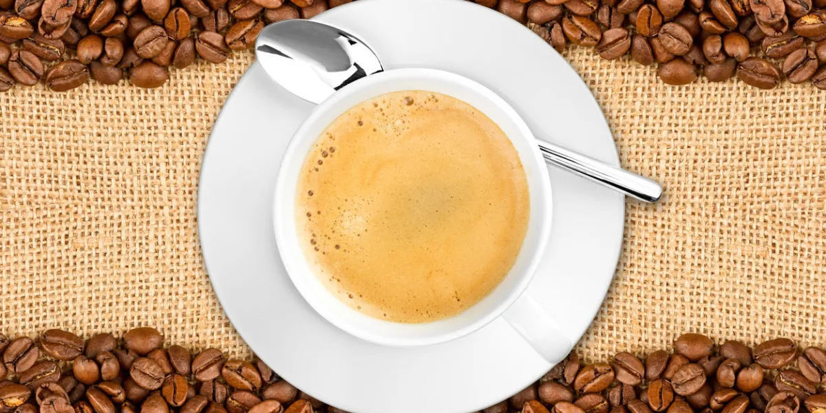 grains de café et tasse sur fond de jute