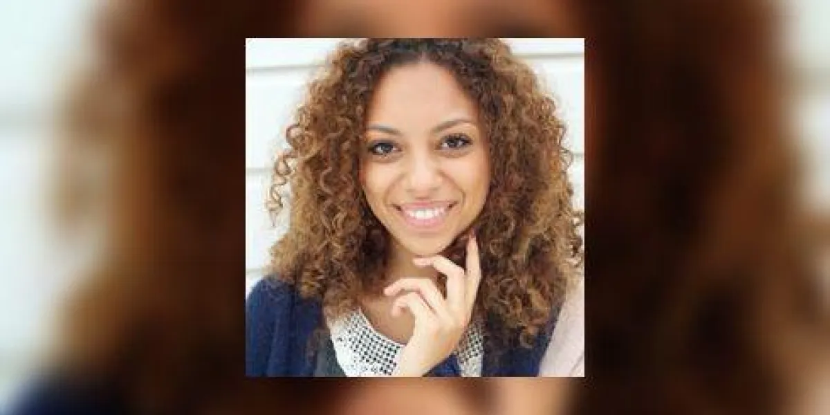 belle jeune femme aux cheveux bouclés, souriant à l'extérieur
