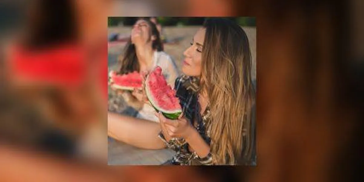copines rire et manger pastèque sur la plage coucher de soleil