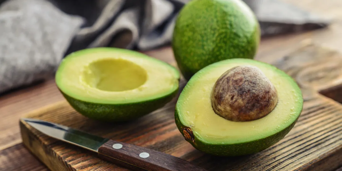 fresh avocado on cutting board over wooden background