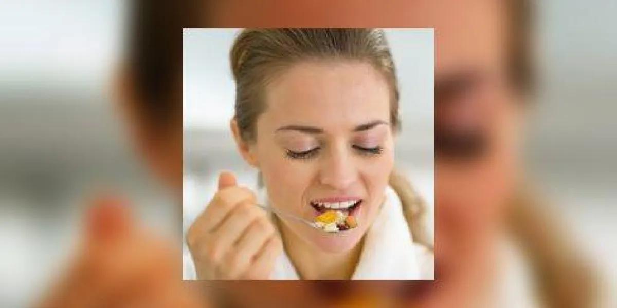 portrait de jeune femme mangeant muesli en cuisine portrait de jeune femme mangeant muesli en cuisine