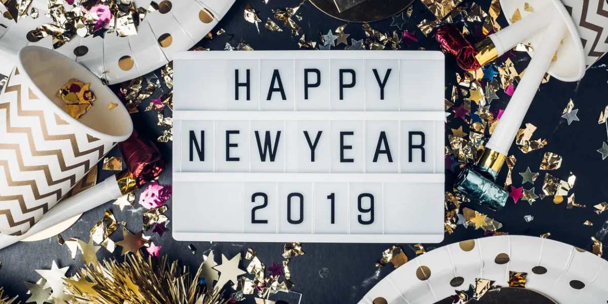 happy new year 2019 on light box with party cup,party blower,tinsel,confettifun celebrate holiday party time table top view